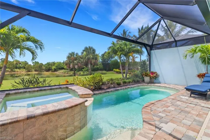 View of swimming pool with a pool with connected hot tub, a lanai, a sunroom, and a patio area