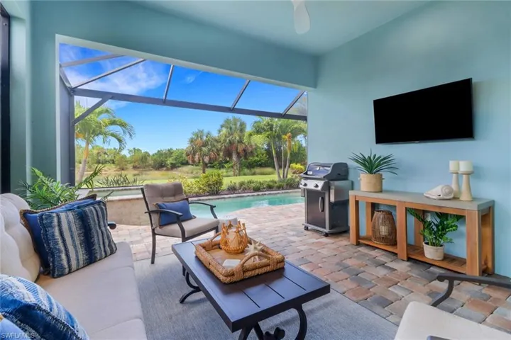 View of patio featuring an outdoor pool, a sunroom, glass enclosure, grilling area, and a ceiling fan