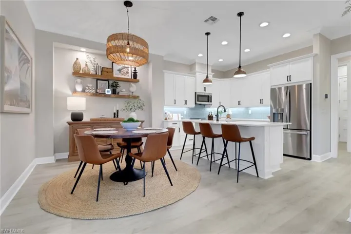 Dining room with light wood finished floors, recessed lighting, and ornamental molding