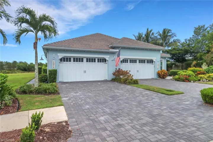 View of front of home with decorative driveway, stucco siding, and an attached garage