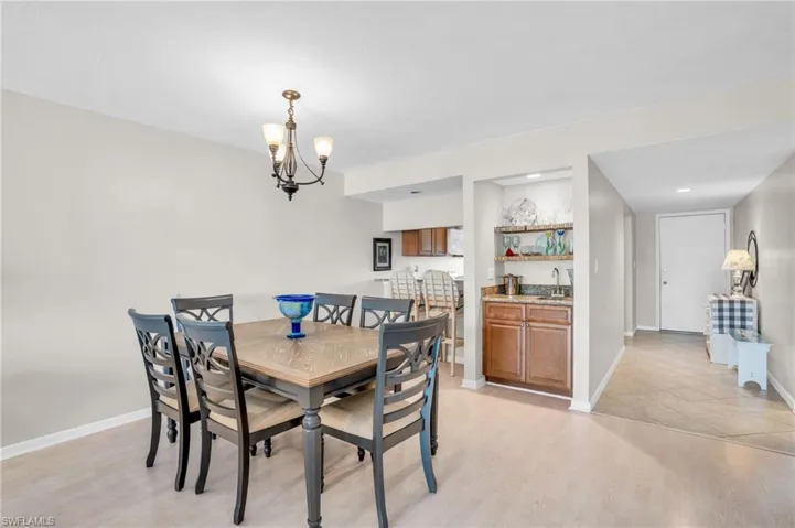 Dining room with sink, a notable chandelier, and light hardwood / wood-style floors