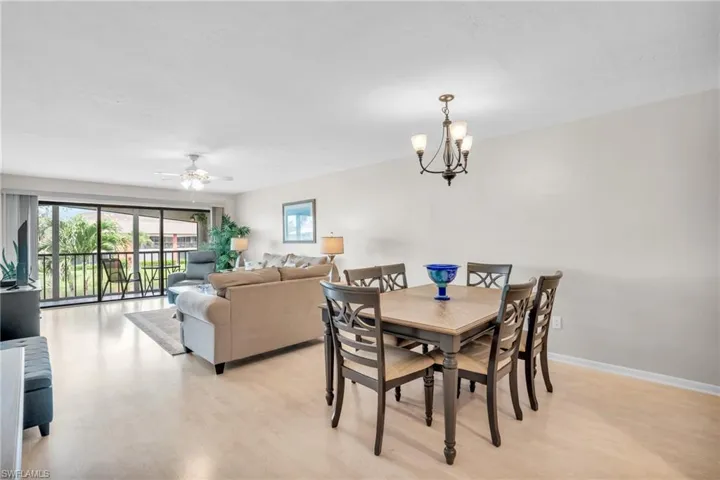 Dining area with ceiling fan with notable chandelier and light wood-type flooring