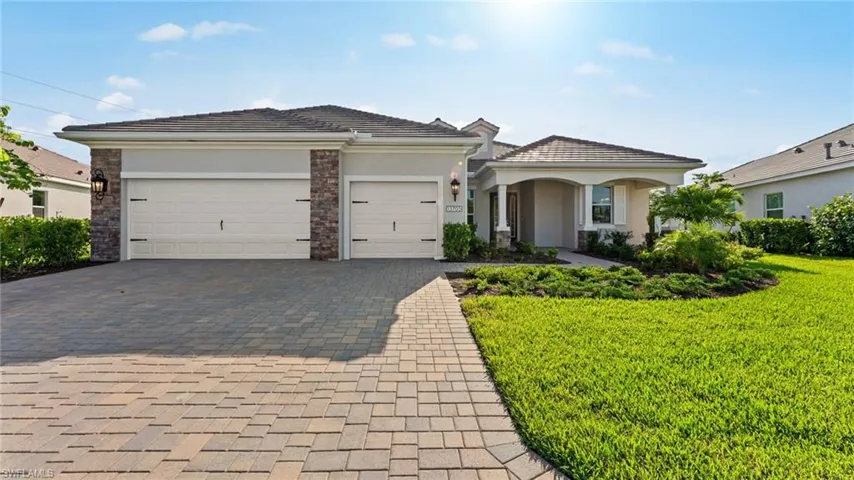 View of front of property featuring a garage and a front yard