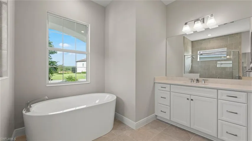 Bathroom featuring tile floors, a washtub, and vanity