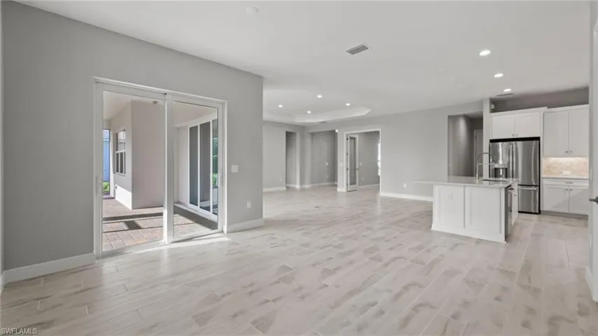 Unfurnished living room with a tray ceiling and light hardwood / wood-style floors