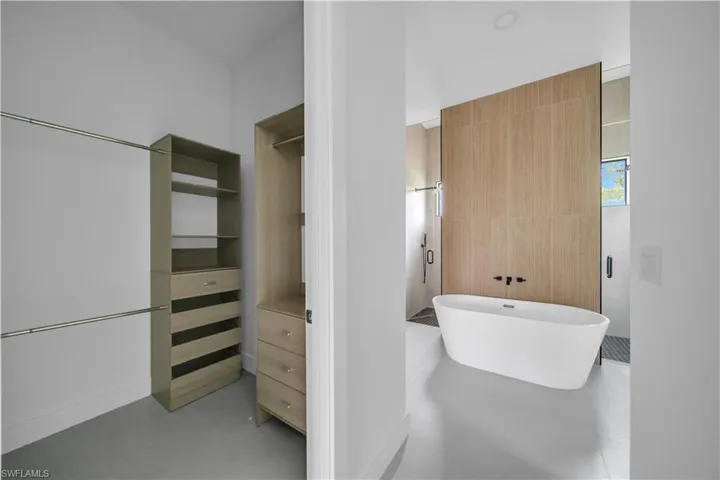 Full bath with a freestanding bath, a stall shower, and tile walls