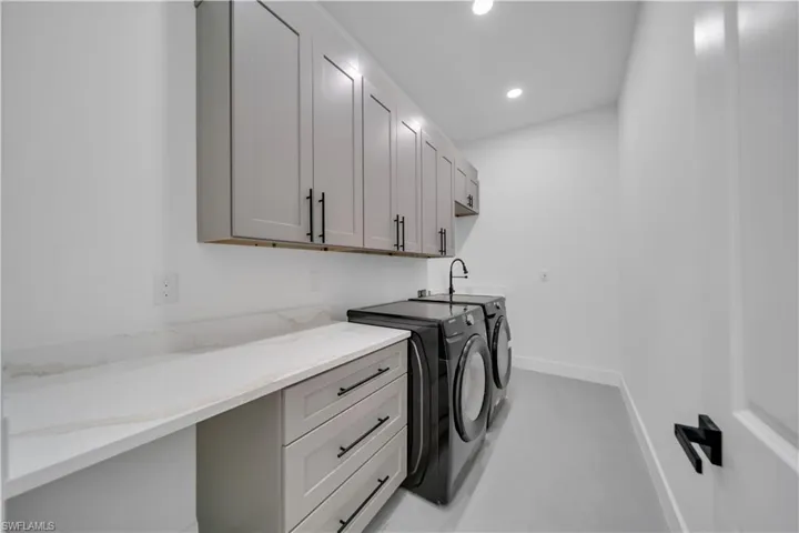 Laundry area with washing machine and clothes dryer, cabinet space, and recessed lighting