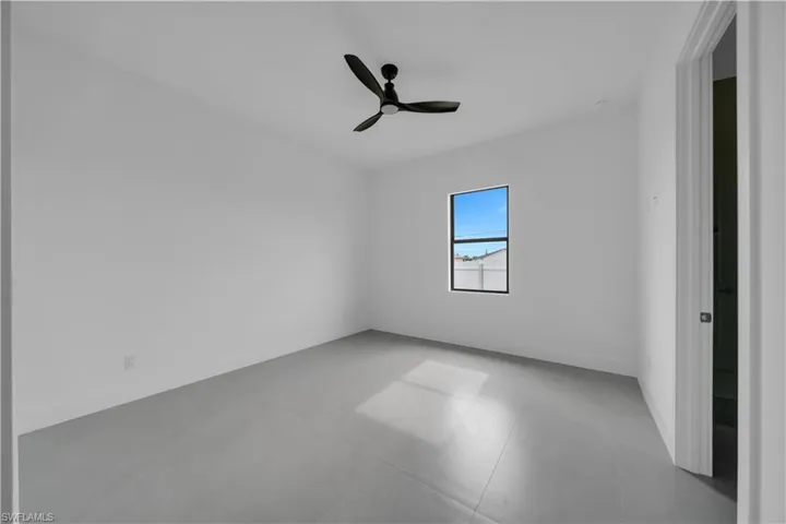 Spare room featuring ceiling fan and baseboards