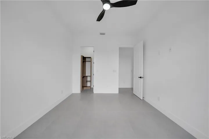 Unfurnished bedroom with light tile patterned flooring and a ceiling fan