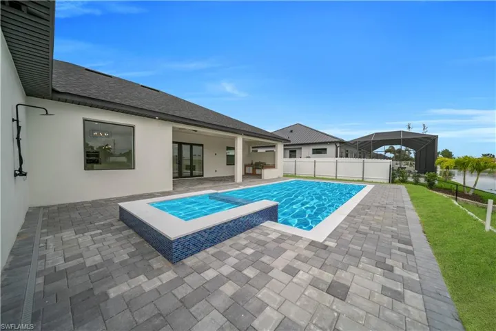 View of pool with a patio and a pool with connected hot tub