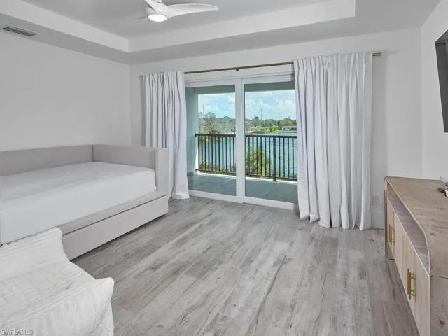 Guest bedroom featuring tray ceilings, and a private outside balcony.