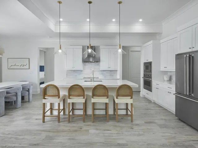 Kitchen with large island, bar seating, and suite of stainless steel appliances