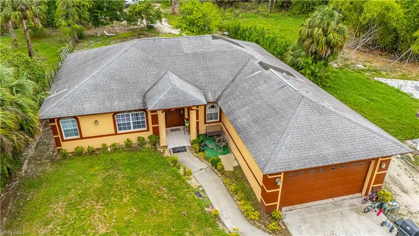 View of front of house featuring a front yard, a shingled roof, and stucco siding