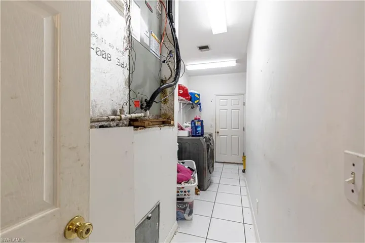 Laundry area featuring washer and dryer, tile patterned flooring, and baseboards