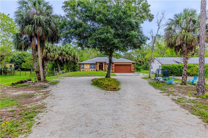 View of front of house featuring dirt driveway and a garage