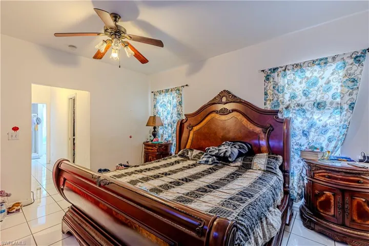 Bedroom with light tile patterned floors and ceiling fan