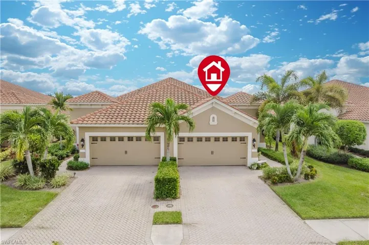 Mediterranean / spanish-style home with stucco siding, a front yard, a tile roof, and decorative driveway