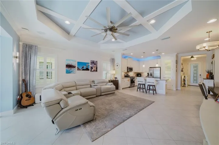 Living area featuring coffered ceiling, recessed lighting, a ceiling fan, light tile patterned flooring, and beamed ceiling