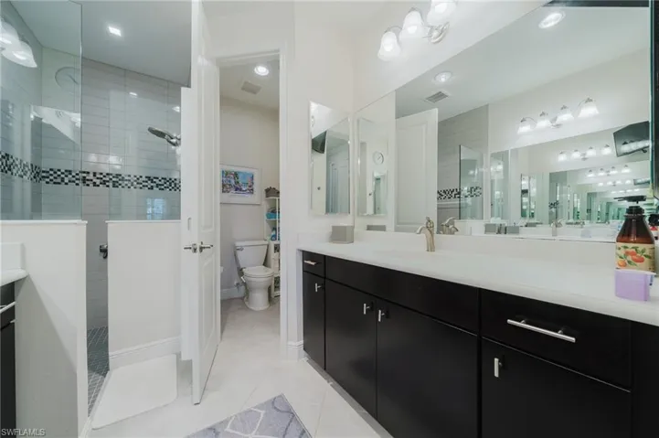 Full bathroom featuring vanity, walk in shower, and light tile patterned floors