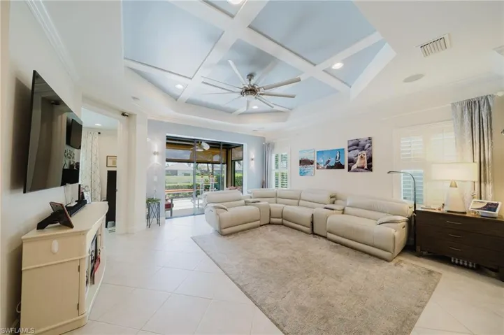 Living room featuring a ceiling fan, coffered ceiling, crown molding, recessed lighting, and light tile patterned floors