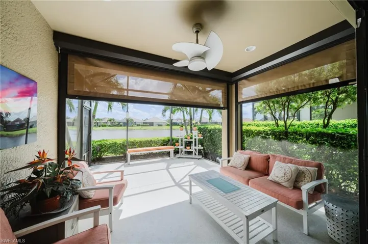 Sunroom / solarium with ceiling fan, outdoor lounge area, a water view, and a textured wall