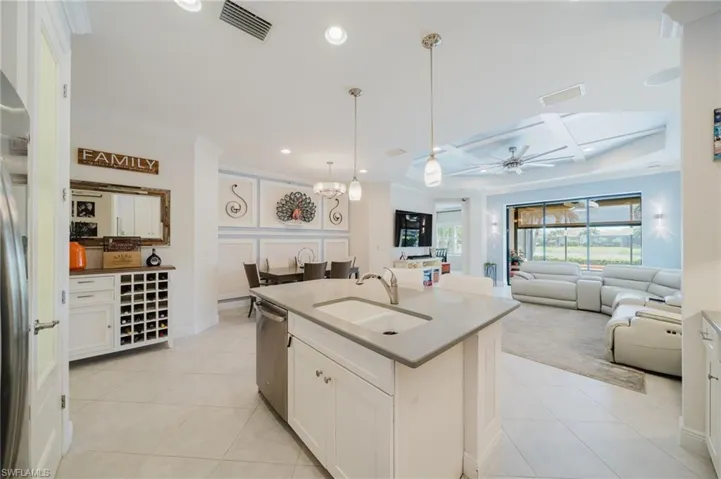 Kitchen with white cabinetry, pendant lighting, open floor plan, light tile patterned floors, and recessed lighting