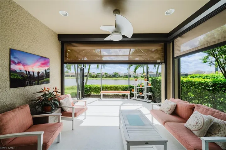 Sunroom featuring a textured wall, a water view, and recessed lighting