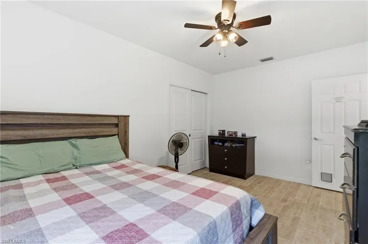 Bedroom featuring light wood finished floors, ceiling fan, and a closet