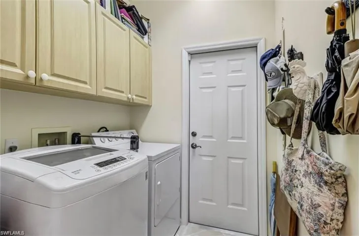 Laundry area with cabinets, separate washer and dryer, and light tile patterned floors