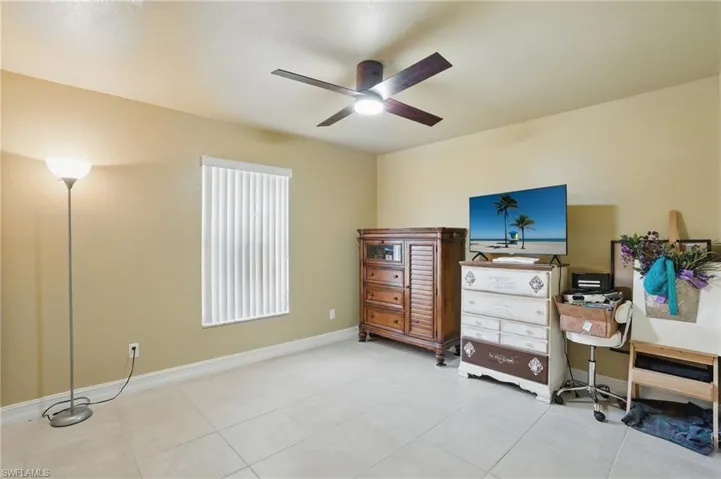 3rd Bedroom with light tile patterned floors, ceiling fan, and baseboards