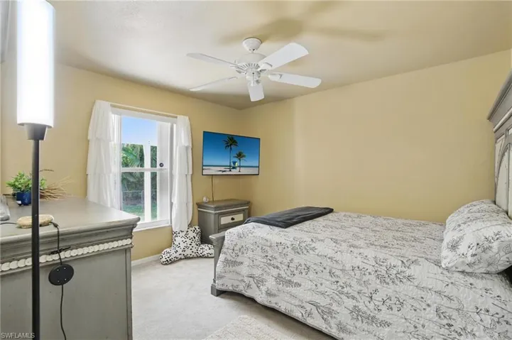Guest Bedroom featuring baseboards, light carpet, and ceiling fan