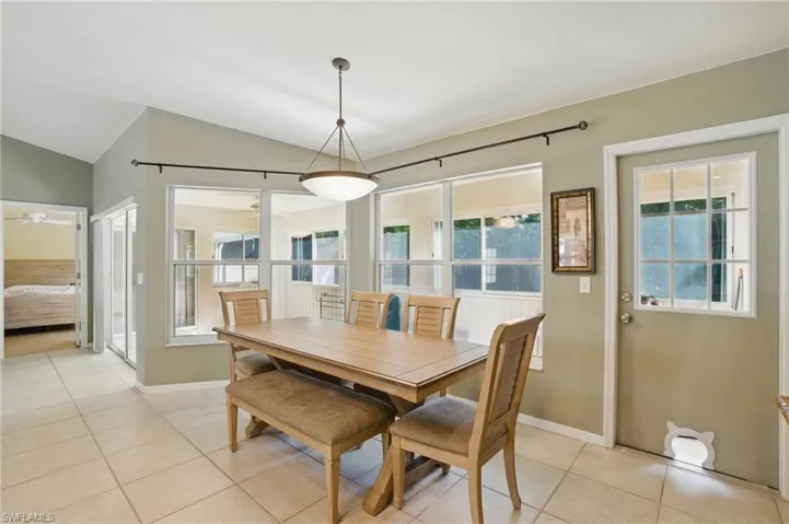Dining area with baseboards, lofted ceiling, light tile patterned flooring, and a ceiling fan