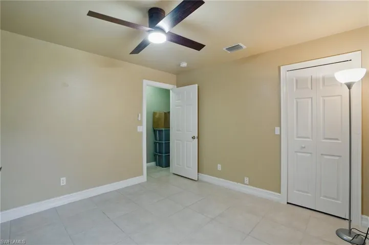 3rd bedroom featuring light tile patterned floors, baseboards, visible vents, and ceiling fan