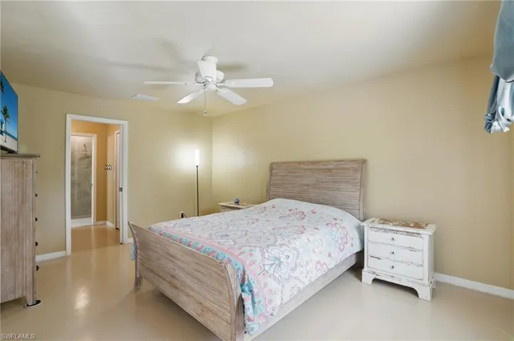Bedroom with visible vents, baseboards, concrete flooring, and a ceiling fan