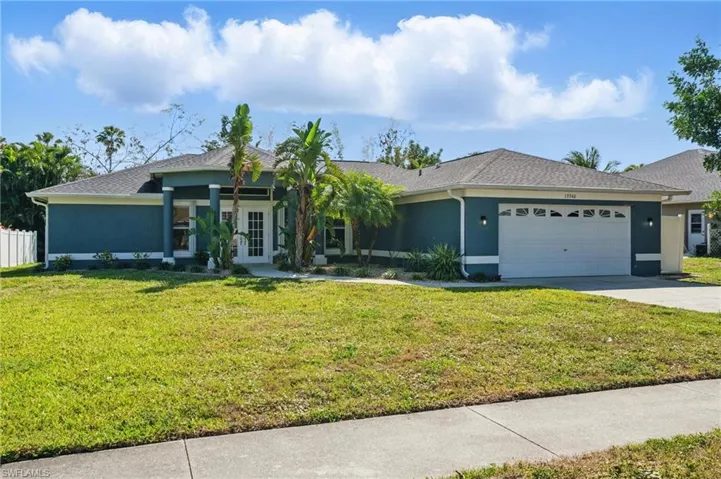 Single story home featuring a front yard, stucco siding, french doors, a garage, and driveway