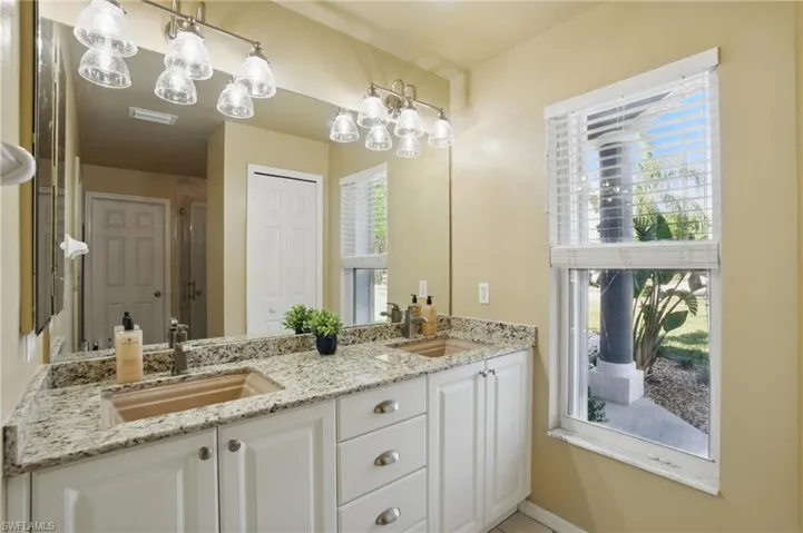 Bathroom with a sink, visible vents, and plenty of natural light