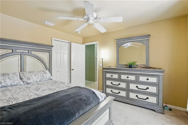 Guest Bedroom with visible vents, baseboards, ceiling fan, a closet, and light carpet