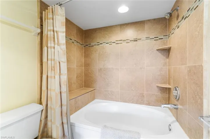 Shower / tub combo in primary bathroom is beautifully tiled