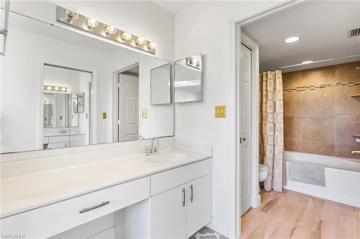Primary bath with extra-wide vanity, and separate water closet with recessed lighting and shower / bath combination
