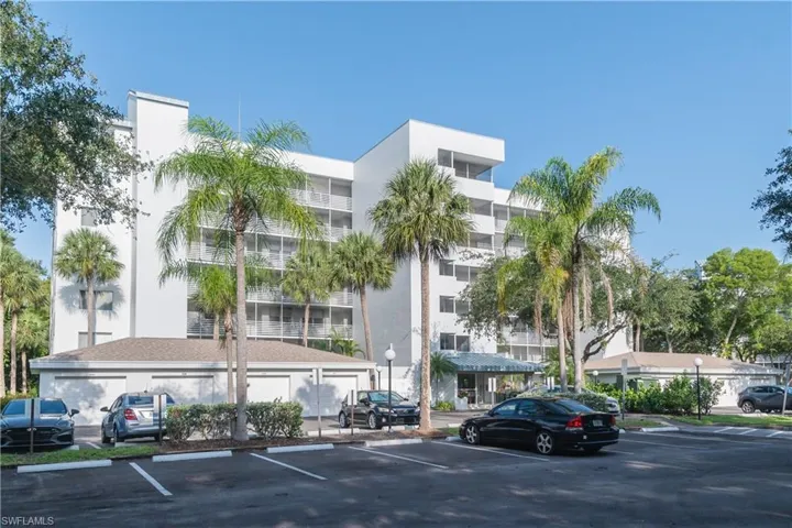 View of apartment building / complex with uncovered parking