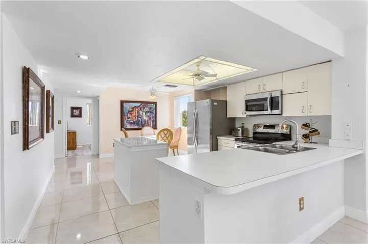 The bright, open kitchen features stainless steel appliances, island and peninsula with room for seating.
