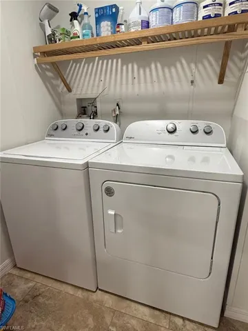 Laundry area with washer and dryer and baseboards
