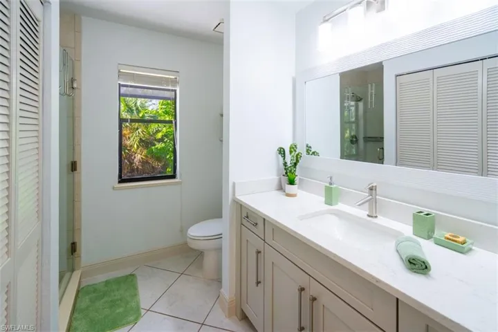Bathroom featuring a closet, vanity, a shower stall, and tile patterned floors