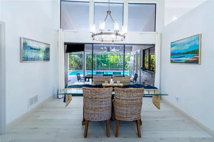 Dining area with wood finished floors, a chandelier, and ceiling fan