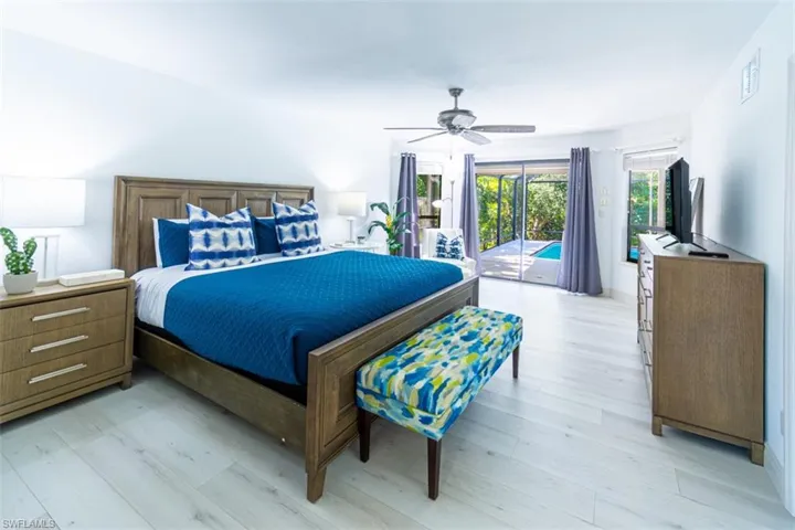 Bedroom with access to exterior, light wood-style flooring, and a ceiling fan