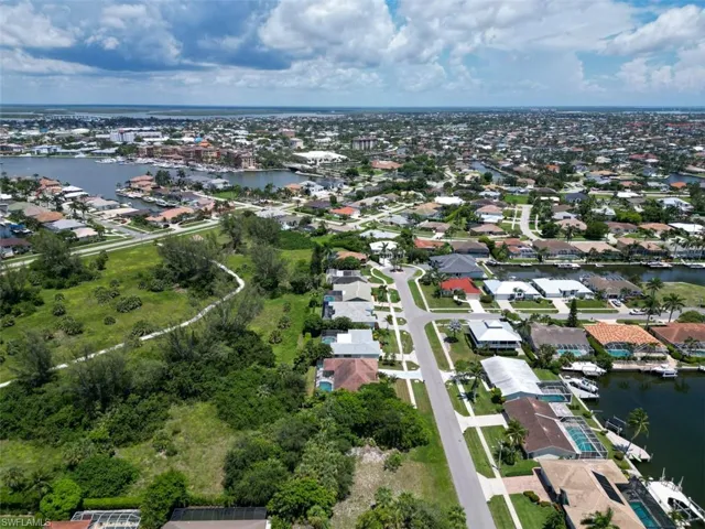 Aerial view of property and surrounding area with a large body of water and nearby suburban area