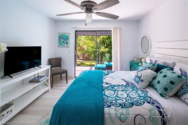 Bedroom with access to outside, wood finished floors, and a ceiling fan