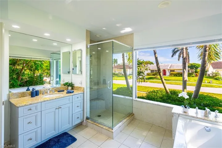 Bathroom featuring vanity, tile patterned flooring, a stall shower, and recessed lighting