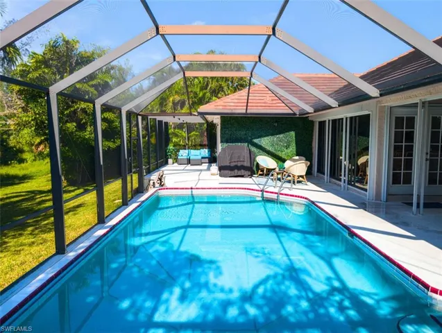 Outdoor pool featuring a patio, a yard, an outdoor hangout area, and a lanai