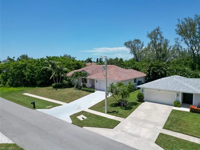Ranch-style home with a garage, concrete driveway, and a front lawn